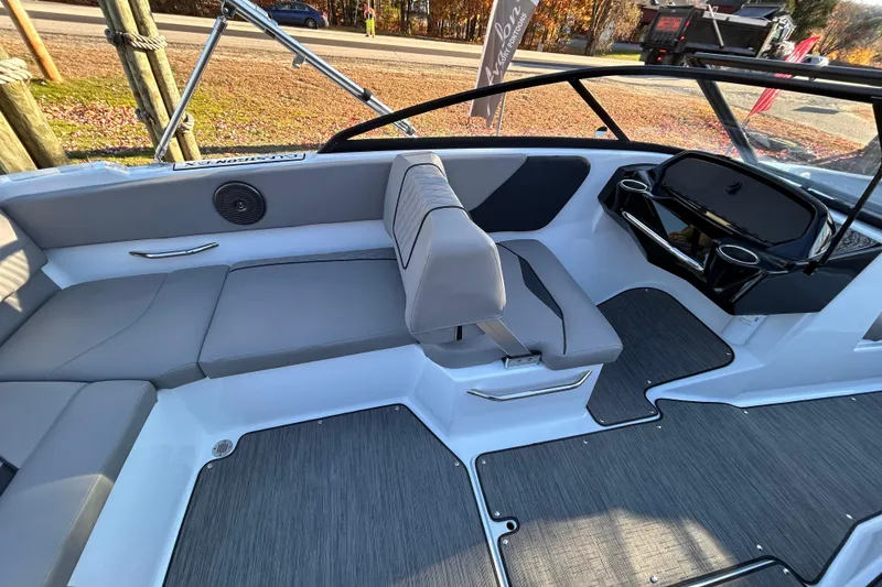 Slide: The Image of 2024 Glastron GX 215 boat interior with gray seating and modern dashboard design. - 30
