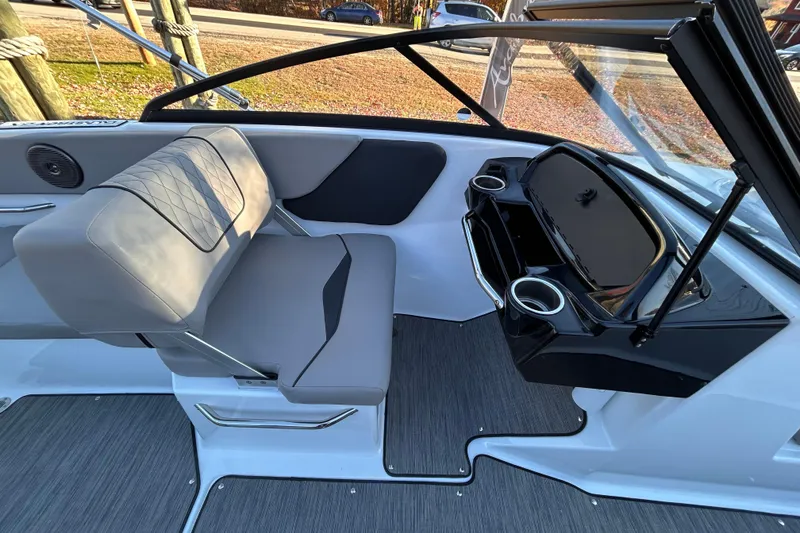 Slide: The Image of 2024 Glastron GX 215 boat interior with gray seating and sleek dashboard design. - 31