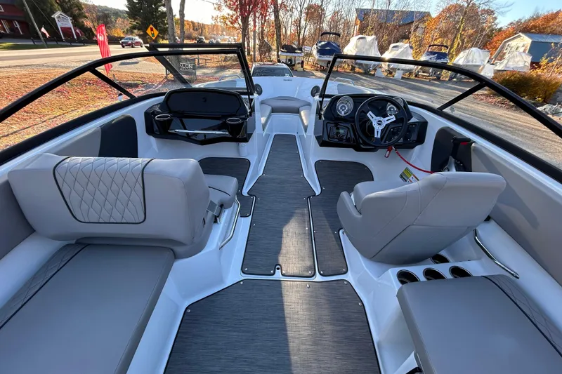 Slide: The Image of 2024 Glastron GX 215 boat interior with modern seating and steering wheel. - 37