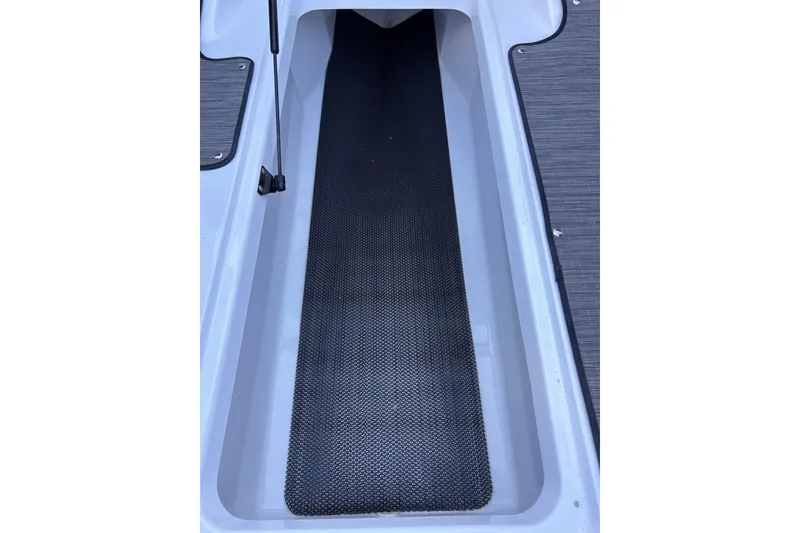 Slide: The Image of 2024 Glastron GX 215 boat storage compartment with black non-slip mat. - 39