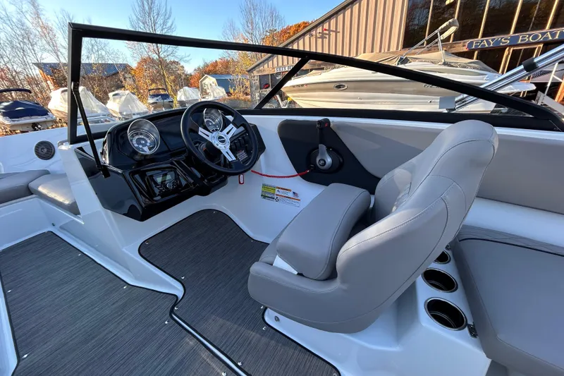 Slide: The Image of 2024 Glastron GX 215 boat interior with steering wheel and gray seating. - 40