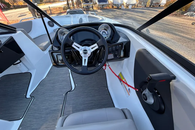 Slide: The Image of 2024 Glastron GX 215 boat cockpit with steering wheel and control panel. - 41