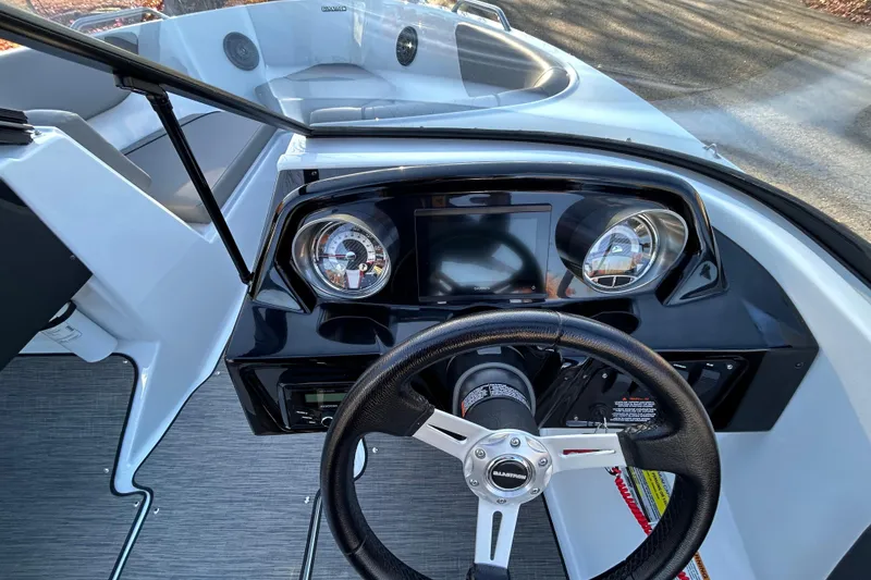 Slide: The Image of 2024 Glastron GX 215 boat dashboard with steering wheel and modern gauges. - 42
