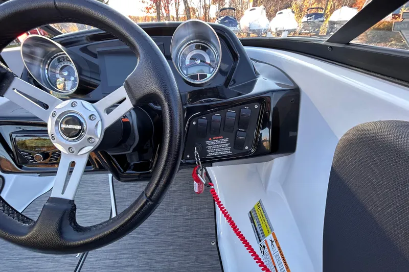 Slide: The Image of 2024 Glastron GX 215 boat dashboard with steering wheel and control panel. - 43