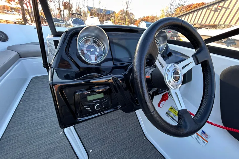 Slide: The Image of 2024 Glastron GX 215 boat dashboard with steering wheel and instrument panel. - 44