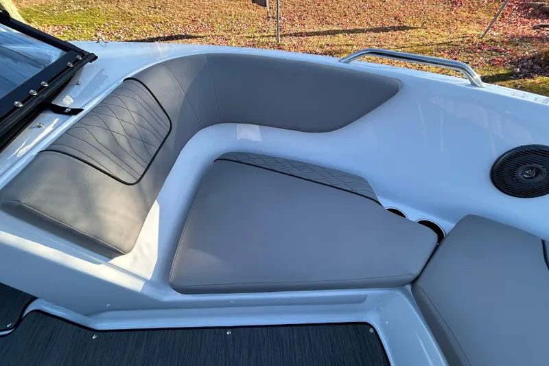 Slide: The Image of 2024 Glastron GX 215 boat interior with gray cushioned seating and cup holders. - 47