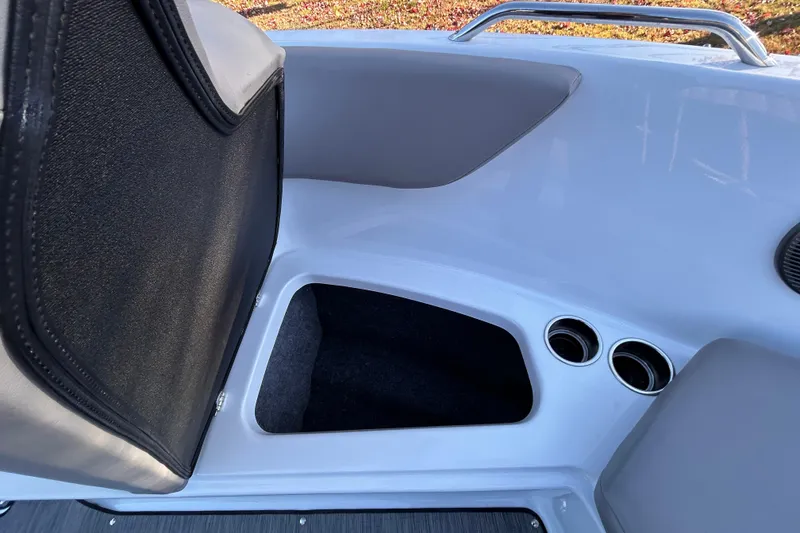 Slide: The Image of 2024 Glastron GX 215 boat interior with storage compartment and cup holders. - 48