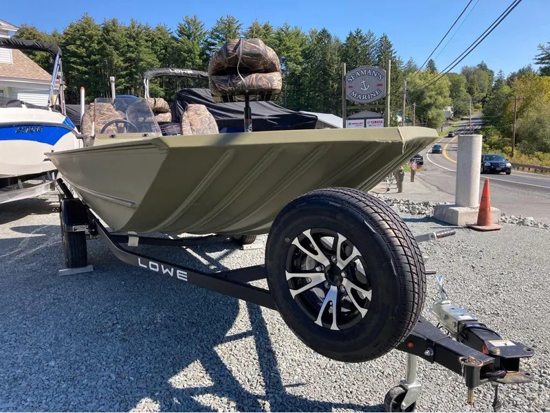 Slide: The Image of 2024 Lowe Roughneck RX1660 SC boat on trailer, parked outdoors near road. - 4