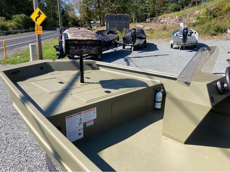 Slide: The Image of 2024 Lowe Roughneck RX1660 SC boat parked on gravel near road and other boats. - 6