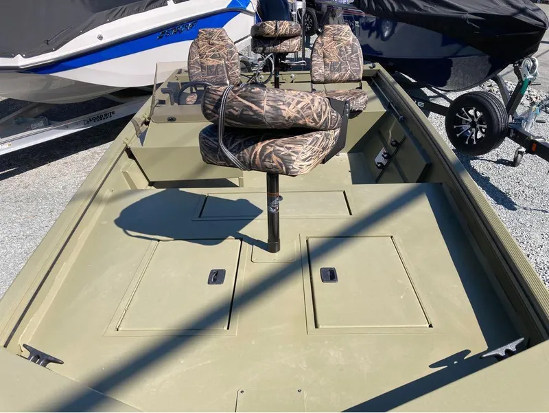 Slide: The Image of 2024 Lowe Roughneck RX1660 SC boat with camouflage seats and storage compartments. - 8