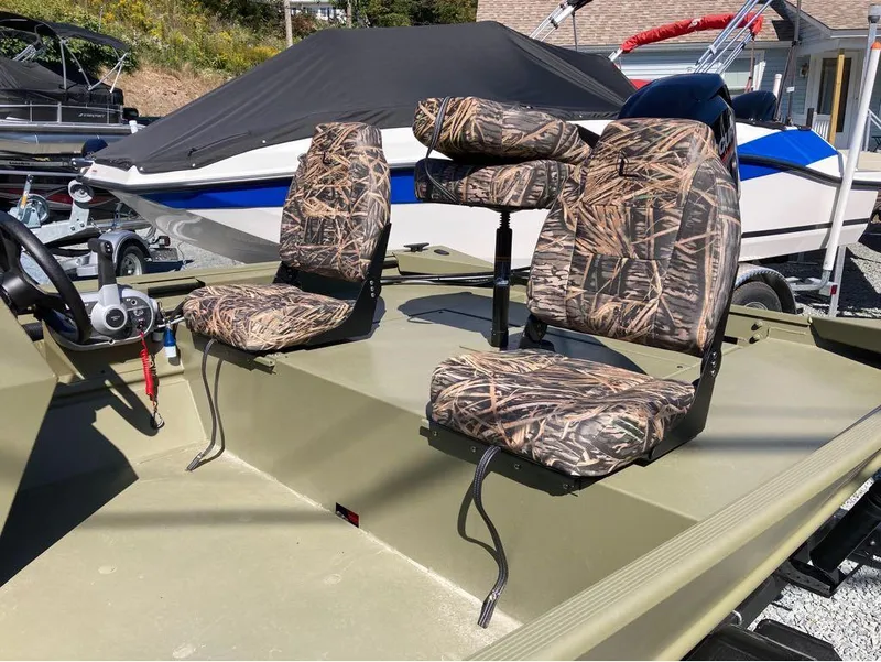Slide: The Image of 2024 Lowe Roughneck RX1660 SC boat with camo seats, parked outdoors. - 9