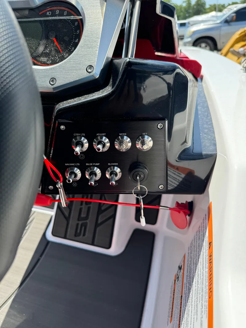 Slide: The Image of Dashboard controls of a 2025 Scarab 165 ID boat with key ignition and switches. - 11