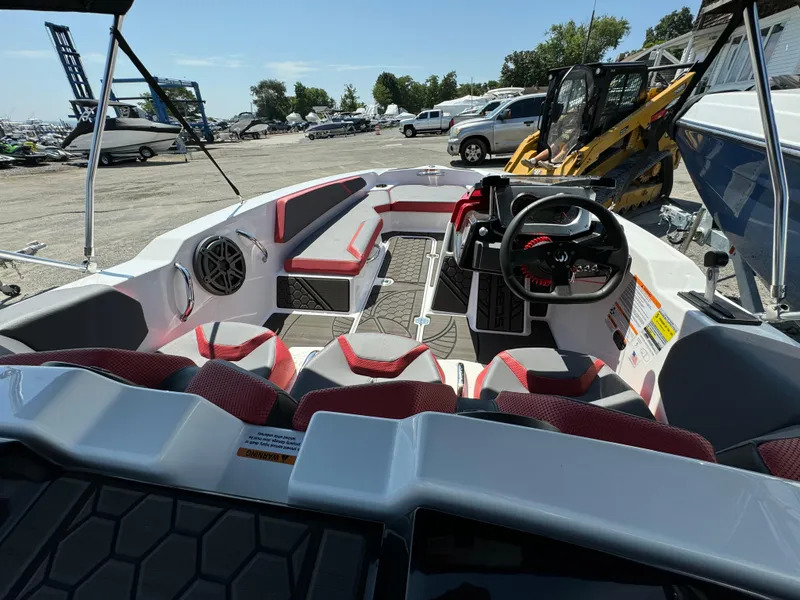 Slide: The Image of 2025 Scarab 165 ID boat interior with red and white seating, steering wheel, and speaker. - 14