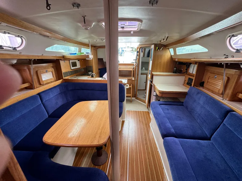 Slide: The Image of Interior of a 2005 Catalina 34 Mk II sailboat with blue seating and wooden accents. - 15