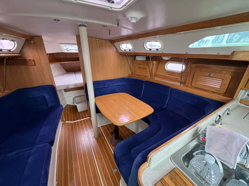 Slide: The Image of Interior of 2005 Catalina 34 Mk II sailboat with blue seating and wooden finishes. - 16