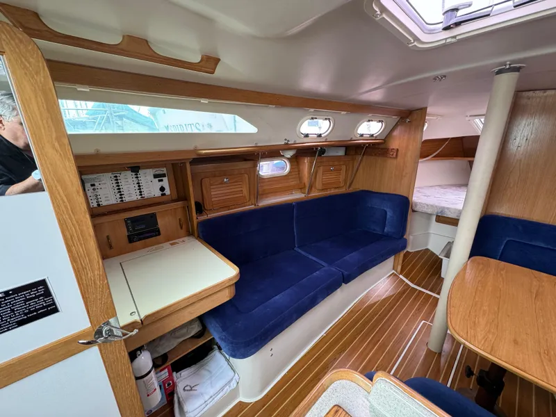 Slide: The Image of Interior of 2005 Catalina 34 Mk II sailboat with blue seating and wooden finishes. - 17
