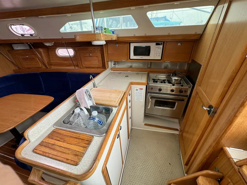 Slide: The Image of 2005 Catalina 34 Mk II yacht interior with kitchen, stove, microwave, and dining area. - 18