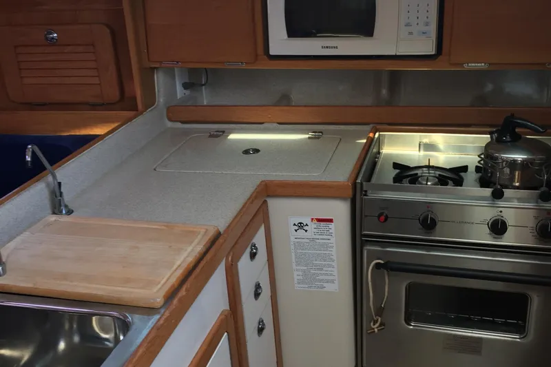 Slide: The Image of 2005 Catalina 34 Mk II yacht kitchen with stove, microwave, and sink. - 20