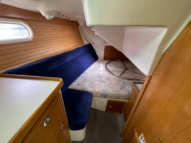 Slide: The Image of Interior cabin of 2005 Catalina 34 Mk II sailboat with blue seating and wooden accents. - 23