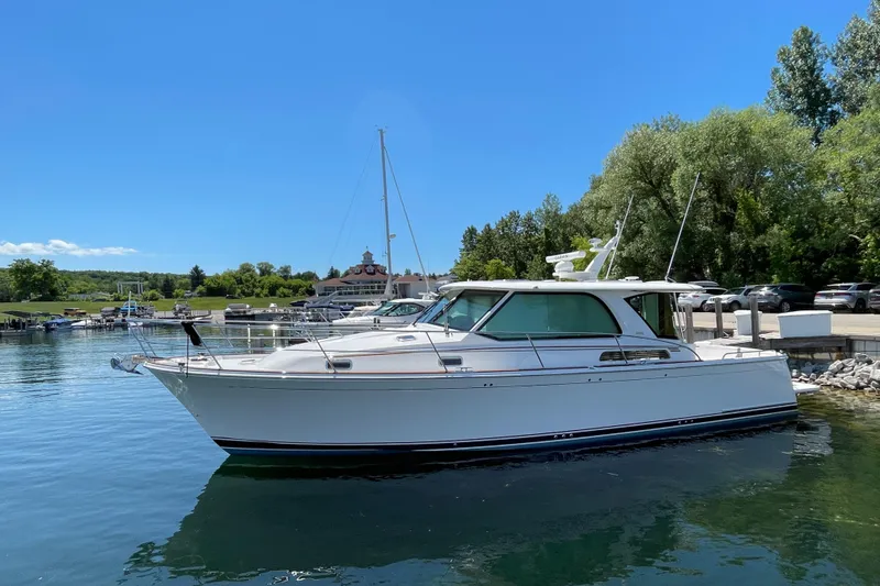 Slide: The Image of 2024 Sabre 43 Salon Express yacht docked in a serene marina setting. - 12