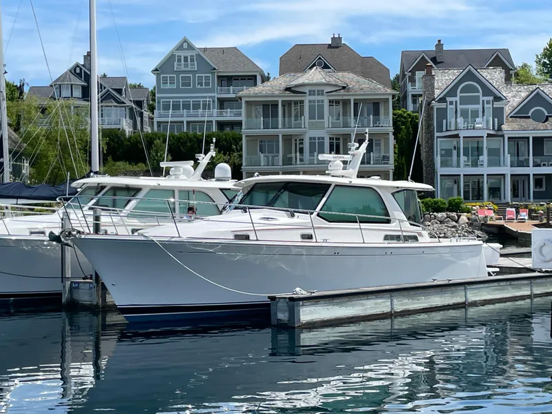 Slide: The Image of 2024 Sabre 43 Salon Express yacht docked in a marina with waterfront homes. - 13