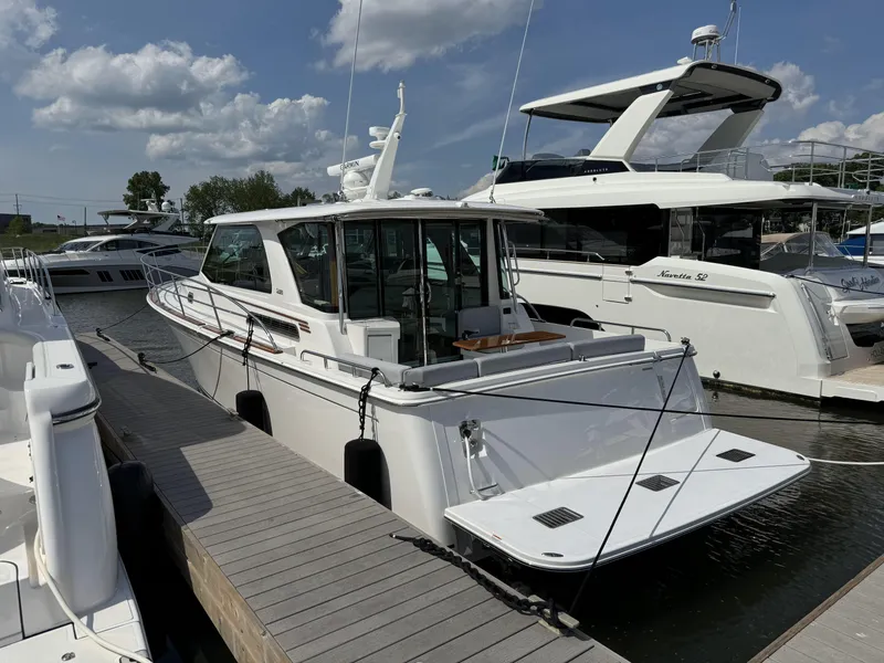 Slide: The Image of 2024 Sabre 43 Salon Express yacht docked at marina under a partly cloudy sky. - 15