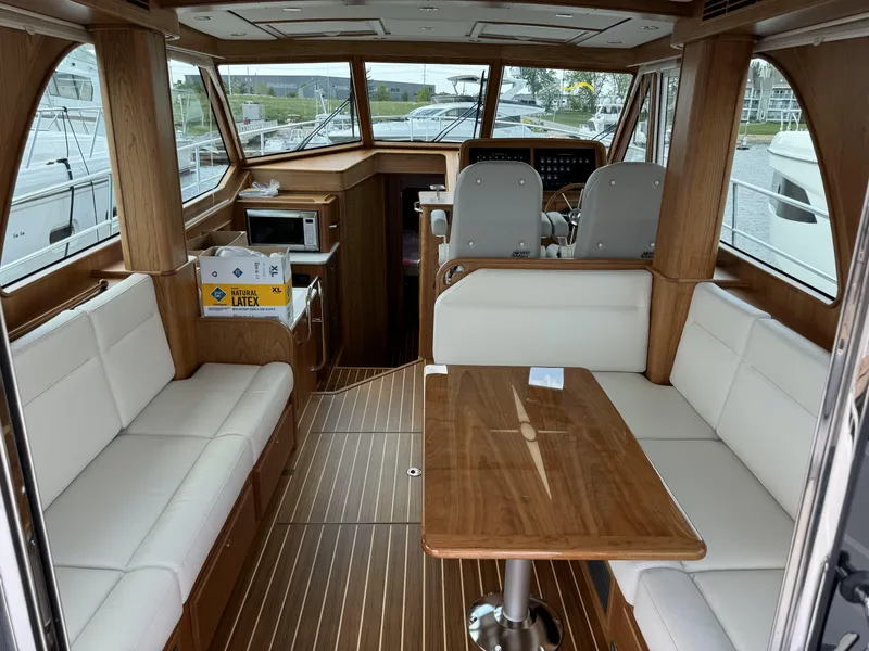 Slide: The Image of 2024 Sabre 43 Salon Express interior with wood finish, white seating, and modern amenities. - 19