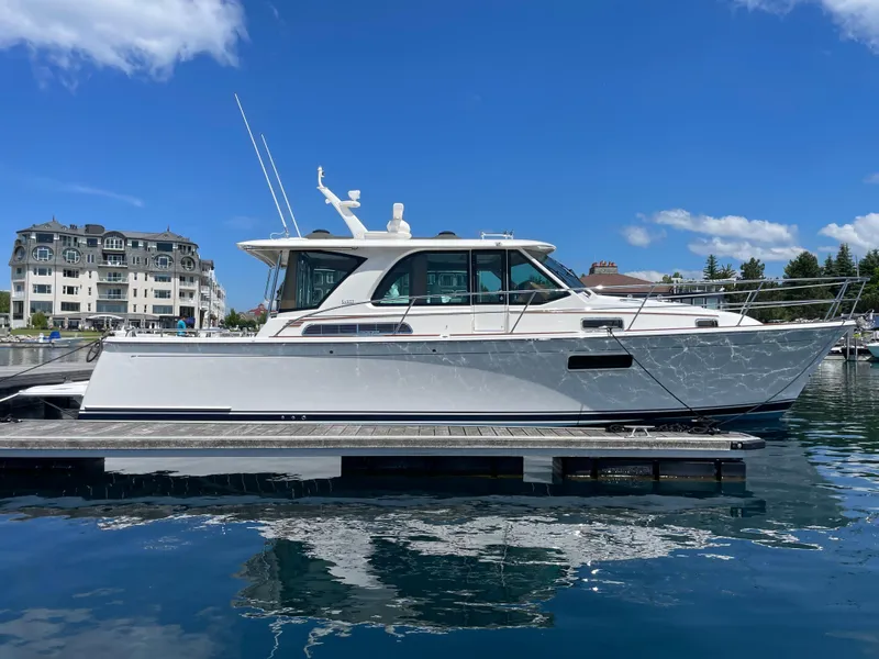 Slide: The Image of 2024 Sabre 43 Salon Express yacht docked in a marina under a clear blue sky. - 2