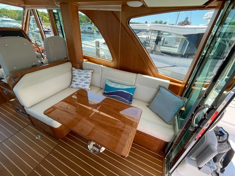 Slide: The Image of 2024 Sabre 43 Salon Express interior with elegant seating and wooden table. - 23