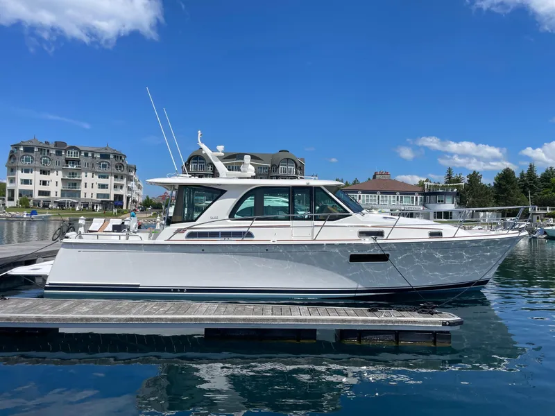 Slide: The Image of 2024 Sabre 43 Salon Express yacht docked at a marina under a clear blue sky. - 3