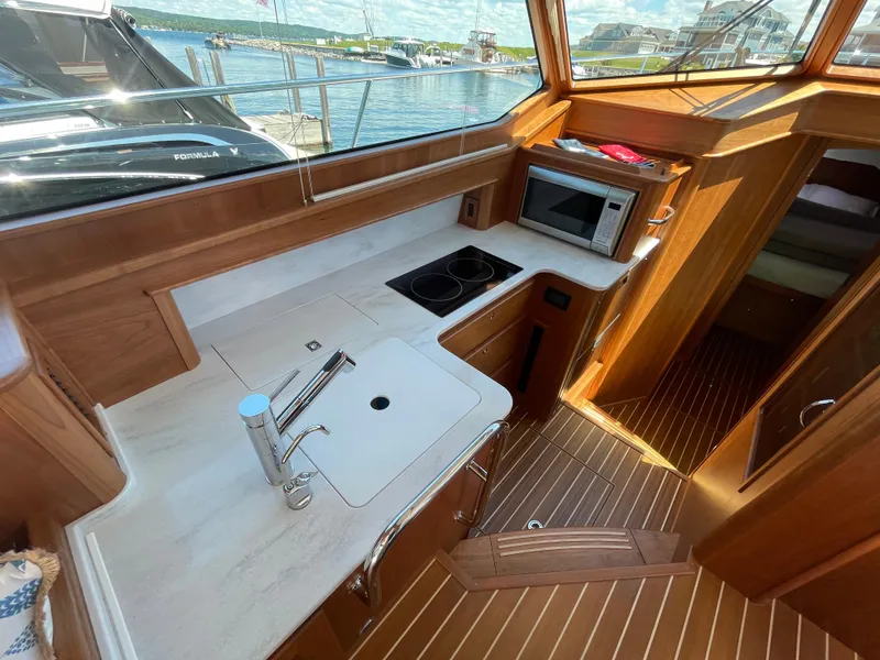 Slide: The Image of 2024 Sabre 43 Salon Express yacht kitchen with modern appliances and wooden interior. - 30
