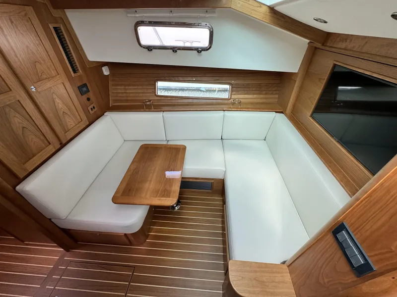 Slide: The Image of 2024 Sabre 43 Salon Express interior with white seating and wooden table. - 33