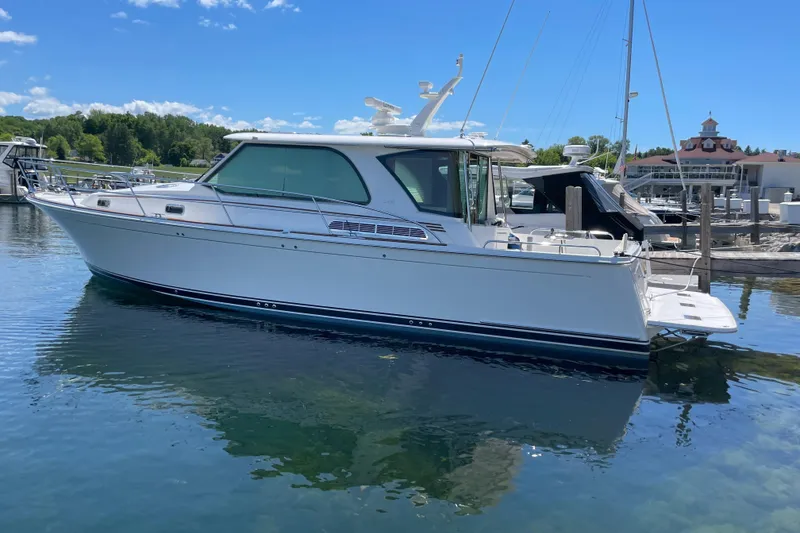 Slide: The Image of 2024 Sabre 43 Salon Express yacht docked in a marina under clear blue skies. - 5