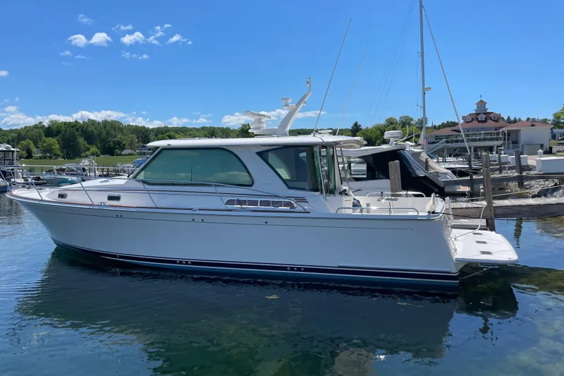 Slide: The Image of 2024 Sabre 43 Salon Express yacht docked in a marina under a clear blue sky. - 6