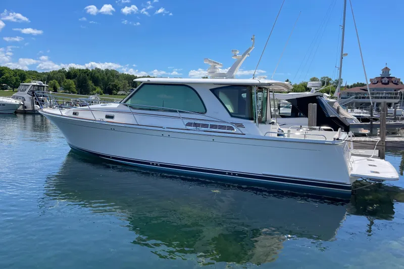 Slide: The Image of 2024 Sabre 43 Salon Express yacht docked in a serene marina setting. - 7