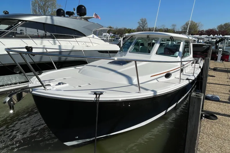 Slide: The Image of 2024 Back Cove 34O boat docked in marina, sleek design, white hull, sunny day. - 10