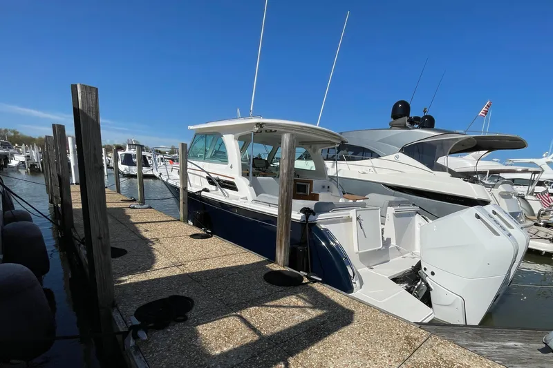 Slide: The Image of 2024 Back Cove 34O boat docked at marina under clear blue sky. - 13