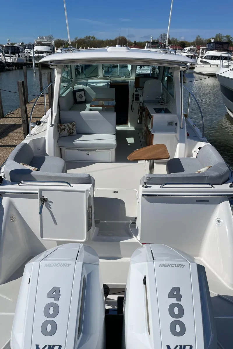 Slide: The Image of 2024 Back Cove 34O boat with twin Mercury 400 engines, docked at a marina. - 19