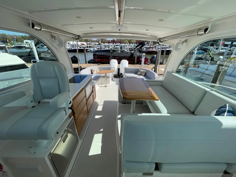 Slide: The Image of 2024 Back Cove 34O yacht interior with seating, table, and helm station. - 22