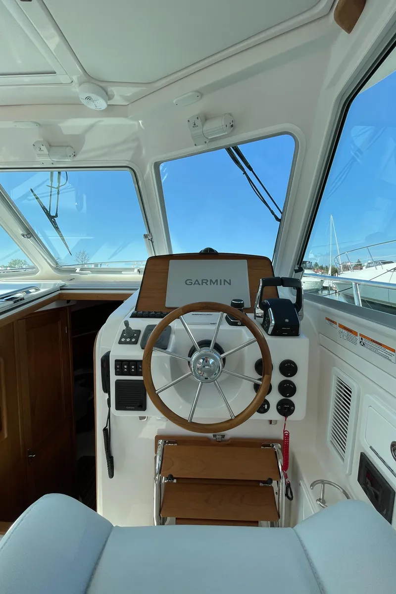 Slide: The Image of 2024 Back Cove 34O helm with Garmin navigation system and wooden steering wheel. - 24