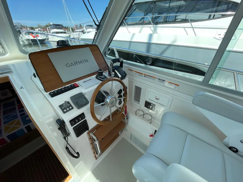 Slide: The Image of 2024 Back Cove 34O helm with Garmin navigation, luxurious seating, and modern controls. - 25