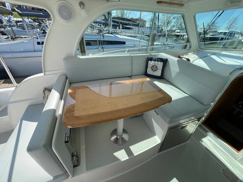 Slide: The Image of 2024 Back Cove 34O yacht interior with elegant seating and wooden table. - 31