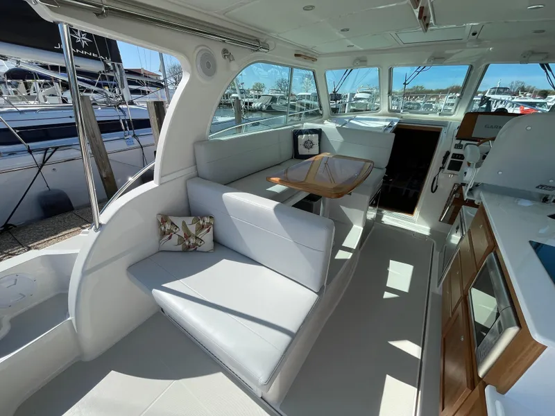 Slide: The Image of 2024 Back Cove 34O yacht interior with seating, table, and helm station. - 32