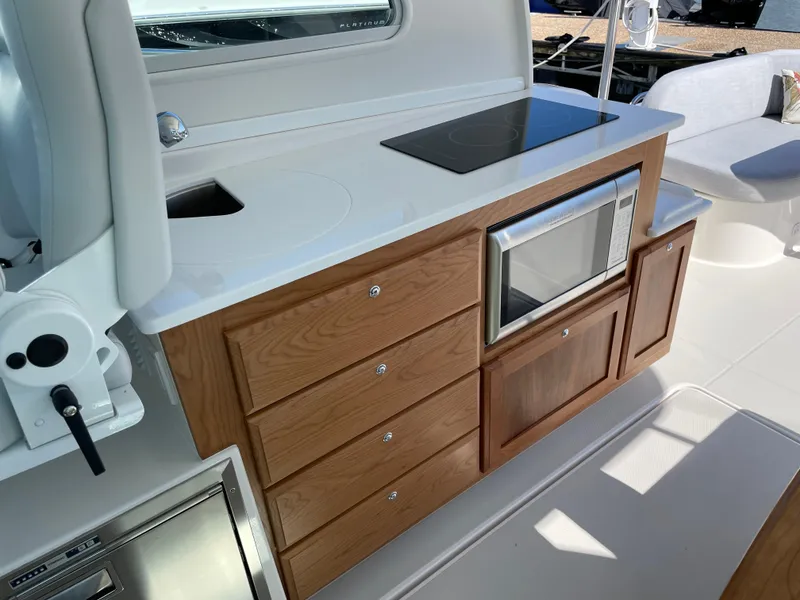 Slide: The Image of 2024 Back Cove 34O yacht kitchen with wooden cabinetry, microwave, and sleek countertop. - 34