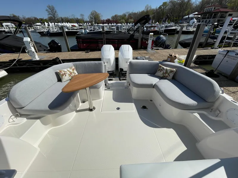 Slide: The Image of 2024 Back Cove 34O boat with spacious seating and table, docked at a marina. - 36