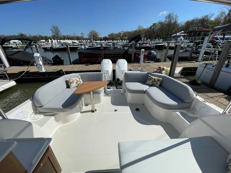 Slide: The Image of 2024 Back Cove 34O boat with spacious seating and table, docked at a marina. - 37