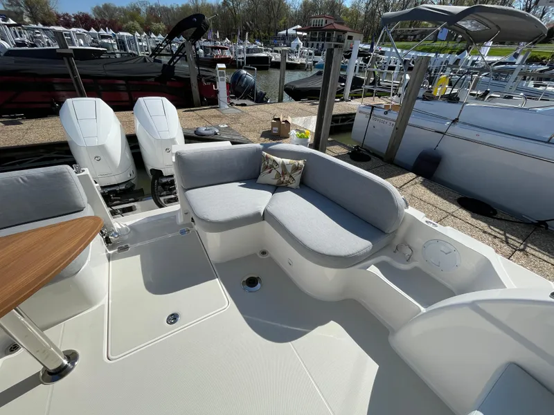 Slide: The Image of 2024 Back Cove 34O boat with cushioned seating and twin outboard engines at a marina. - 39