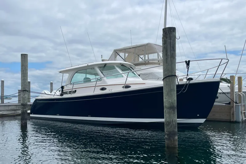 Slide: The Image of 2024 Back Cove 34O boat docked in marina, featuring sleek design and modern amenities. - 4