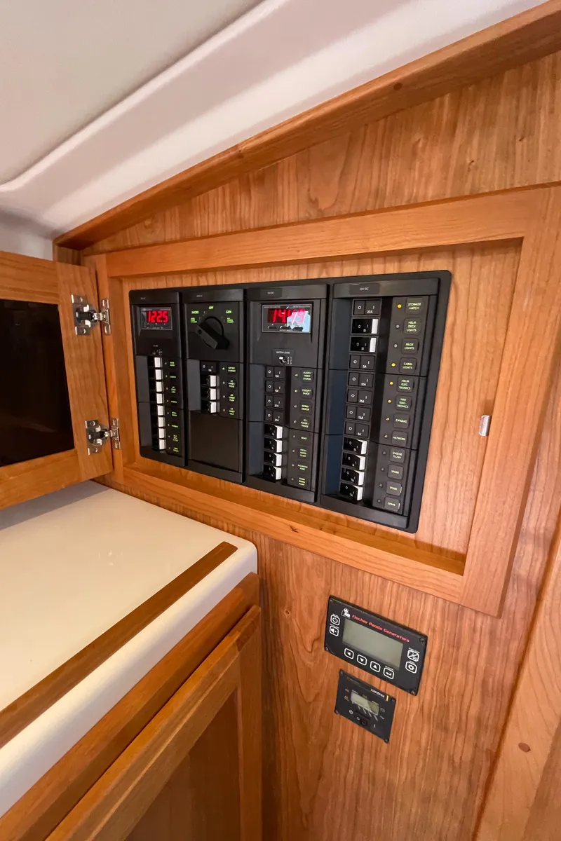 Slide: The Image of 2024 Back Cove 34O electrical panel with wooden cabinetry. - 47