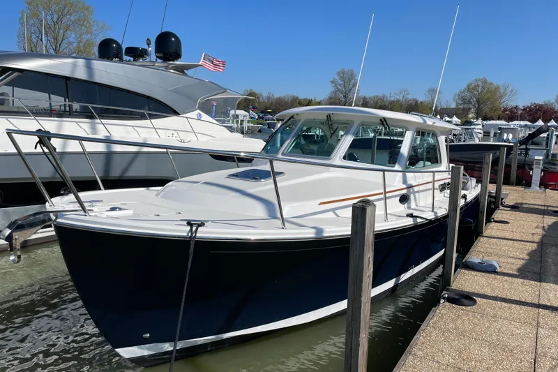 Slide: The Image of 2024 Back Cove 34O boat docked at a marina, featuring a sleek design and modern amenities. - 9